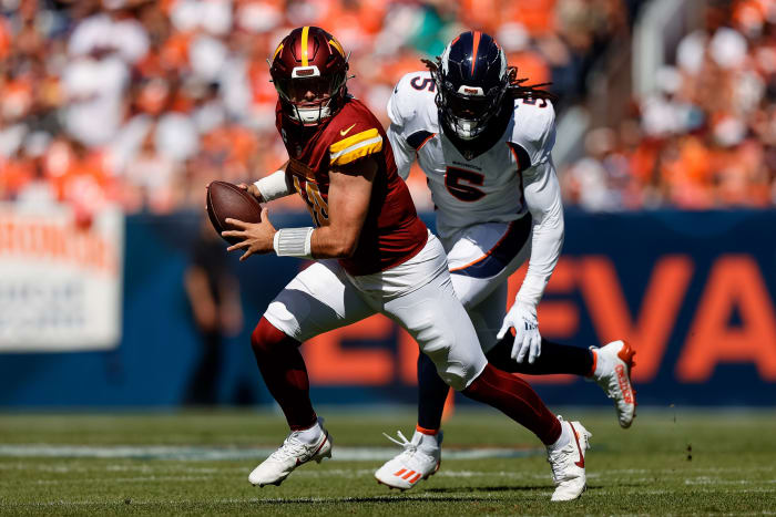 Sep 17, 2023; Denver, Colorado, USA; Washington Commanders quarterback Sam Howell (14) scrambles under pressure from Denver Broncos linebacker Randy Gregory (5) in the first quarter at Empower Field at Mile High. Mandatory Credit: Isaiah J. Downing-USA TODAY Sports